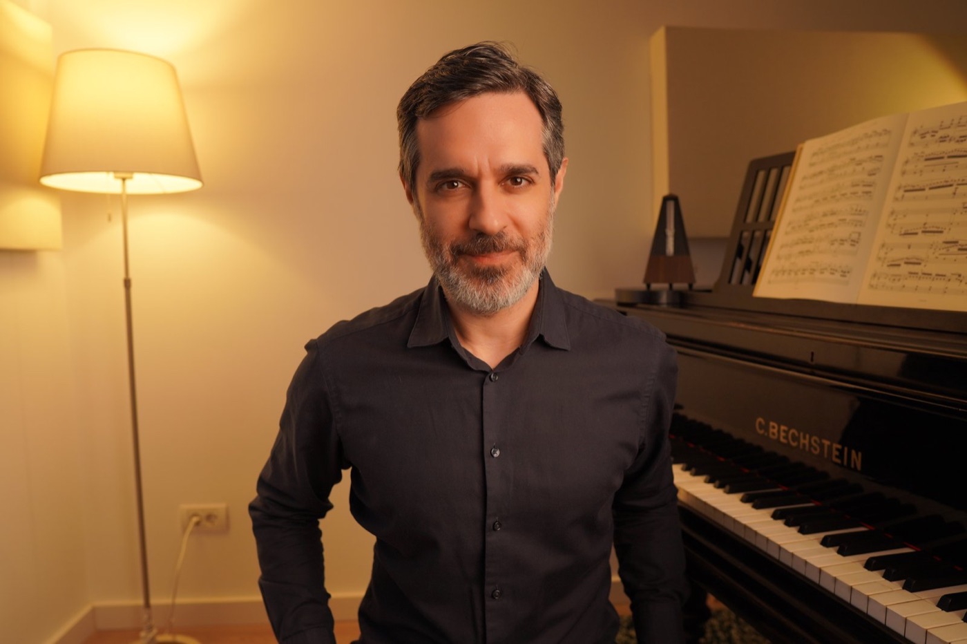 Felipe Scagliusi em pé ao lado do piano